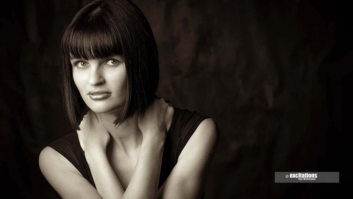 Dramatic brown toned monochrome portrait of beautiful young woman, dramatic, looking straight into the camera. Excitations commercial and editorial photography Mildura.